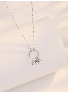 Detail of 925 silver dreamcatcher necklace with circular pendant and zircon tassels