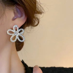 Close-up of elegant flower earring with sparkling zircons worn by a model