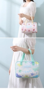 Detail of floral and butterfly print transparent PVC toiletry bags with handle straps