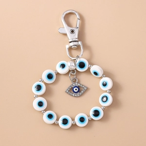 Detailed view of evil eye keychain with blue beads and rhinestone palm pendant charm