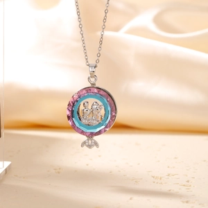 Vintage silver coin necklace with pink and blue crystal pendant on soft silk background