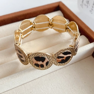 Detailed view of the leopard print elastic bracelet with golden textured circular links