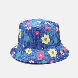 Gros plan d'un chapeau cloche avec imprimés marguerites colorées sur tissu bleu denim