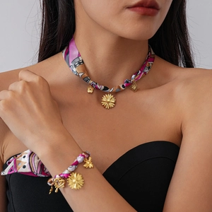 Detail of woven fabric necklace and bracelet set with golden sunflower pendants