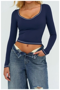 Dettaglio del top da yoga blu scuro slim fit con bordi bianchi a contrasto e scollo