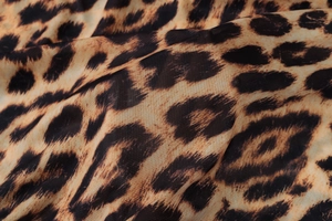 Close-up of leopard print mesh fabric showing detailed texture and animal pattern