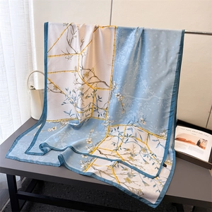 Detailed view of floral silk scarf showing premium stitching and elegant blue border