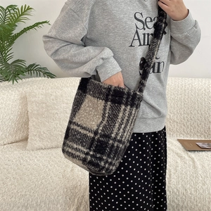 Close-up of fluffy plaid bucket bag with soft faux fur texture and large check pattern