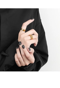 Close-up of golden croissant twist ring and flat band ring set worn on model fingers
