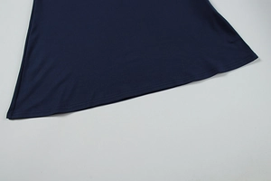 Détail macro de l'ourlet de robe bleu marine avec coutures précises et texture lisse