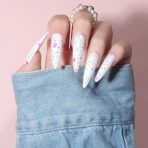 Detailed view of long stiletto press-on nails with colorful sequins and white glitter finish