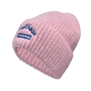 Close-up of pink ribbed knit beanie with blue dog embroidery and text detail