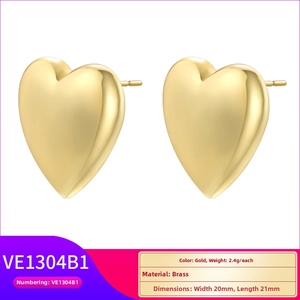 Macro detail of gold-plated brass heart earrings showing 20x21mm size and 2.4g weight