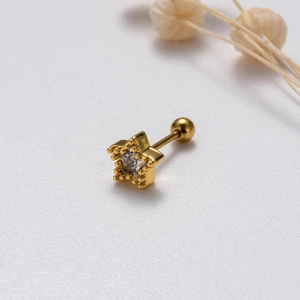 Macro shot of gold star earring with clear zircon and secure screw ball closure