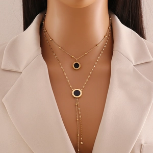 Close-up of double layer gold necklace featuring Roman numeral pendants on a model