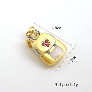 Macro shot of gold backpack pendant with red heart zircon and size specifications
