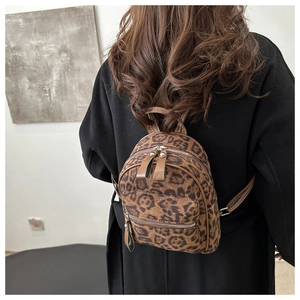 Detailansicht des modischen Mini-Rucksacks mit Leopardenmuster und goldfarbenen Reißverschlüssen