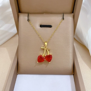 Detail of red cherry pendant necklace with crystals on champagne satin jewelry box
