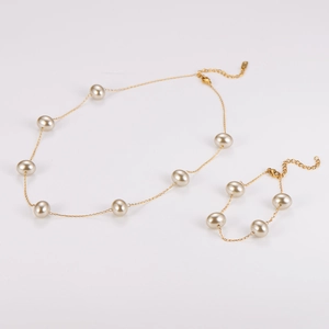 Close-up of a vintage gold-plated necklace and bracelet set with delicate white pearls