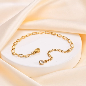 Macro shot of gold flattened twist chain necklace with lobster clasp and zircon drop detail