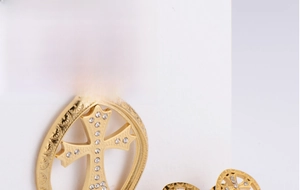 Close-up of gold titanium steel jewelry set with hollow cross pendant and rhinestone detail
