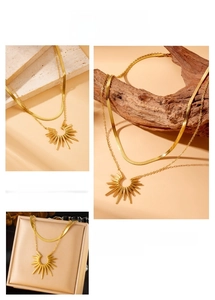 Close-up of double-layer gold snake chain and bohemian sunflower pendant necklace