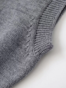 Dettaglio della trama a maglia fine e della cucitura rinforzata su un gilet polo grigio