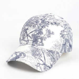 Detail of blue Toile de Jouy landscape pattern on white twill cotton baseball cap