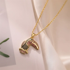 Macro shot of gold-plated toucan pendant featuring vibrant colorful zircon stones