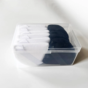 Macro shot of black and white triangular makeup puffs stored in a clear plastic box