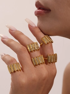 Detail of stacked gold zircon rings featuring micro-pave crystals on the hand