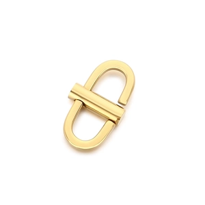 Polished golden stainless steel U-shaped spring buckle hardware on white background