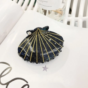 Vue détaillée de la pince à cheveux en forme de coquille bleu foncé avec strass