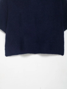 Detail of navy knit sweater showing soft mohair texture and ribbed cuff finishing