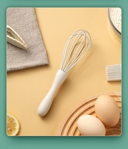 Close-up of a white food-grade silicone whisk on a professional baking background