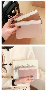 Detail view of lychee-textured leather coin purses with color-block design and wrist straps
