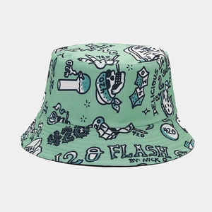 Detail of mint green bucket hat with blue graffiti prints like skulls and text symbols