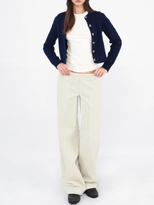 Full view of navy cable knit cardigan paired with white t-shirt and loose cream joggers