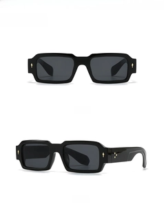 Detail view of black rectangular sunglasses featuring gold diamond rivets on the frame