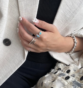 Close-up of minimalist 925 silver rings and twisted rope bracelet on a fashion model