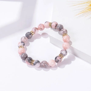 Macro shot of 8mm pink zebra stone beads and gold rhinestone spacer on a stretch bracelet