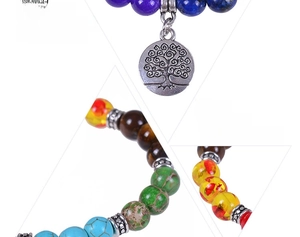 Macro detail of natural seven chakra yoga beads featuring an antique silver tree of life charm