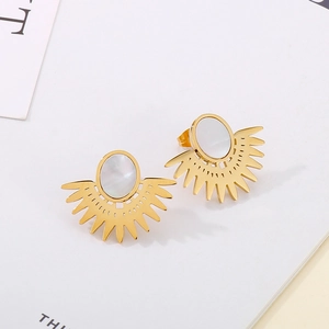 Détail macro de boucles d'oreilles dorées en forme d'éventail avec incrustation nacrée