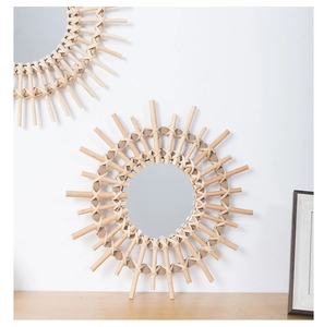 Detail of bohemian sunburst wall mirrors with handmade woven rattan frames on a white wall
