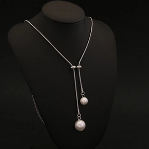 Detail showing elegant silver double-layer Y-shaped chain necklace with pearl pendants