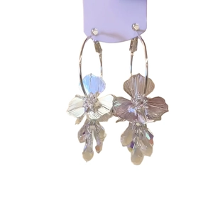 Boucles d'oreilles fleur argentée avec cristaux irisés sur carte violette