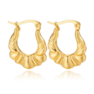 Detailed view of gold croissant hoop earrings with a polished spiral texture on white background