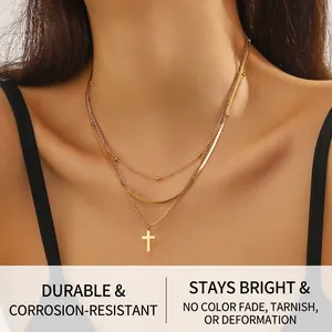 Detailed view of triple-layered gold-plated stainless steel necklace with a cross pendant