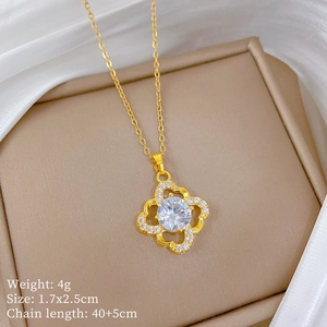 Detail of gold hollow four-leaf clover pendant necklace with sparkling clear crystals