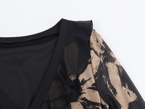 Detail of black round neck dress with printed mesh splicing and ruffle shoulder accents